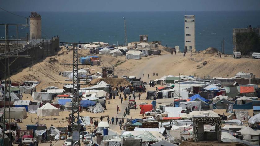 People walk in a camp for displaced people in Rafah in the southern Gaza Strip by the border with Egypt on April 28, 2024, amid the ongoing conflict between Israel and the Palestinian militant group Hamas. AFP