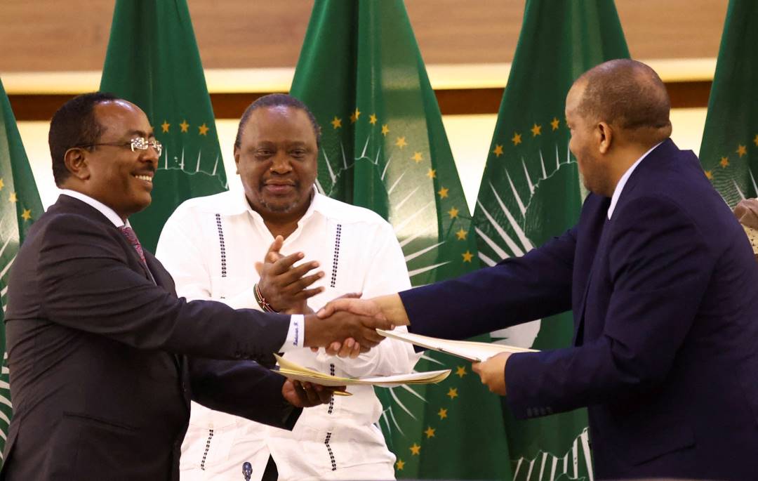 Former Kenyan President Uhuru Kenyatta applauds Ethiopian government representative Redwan Hussien and Tigray delegate Getachew Reda after signing the AU-led negotiations to resolve the conflict in northern Ethiopia. Pretoria, South Africa, Nov. 2, 2022.