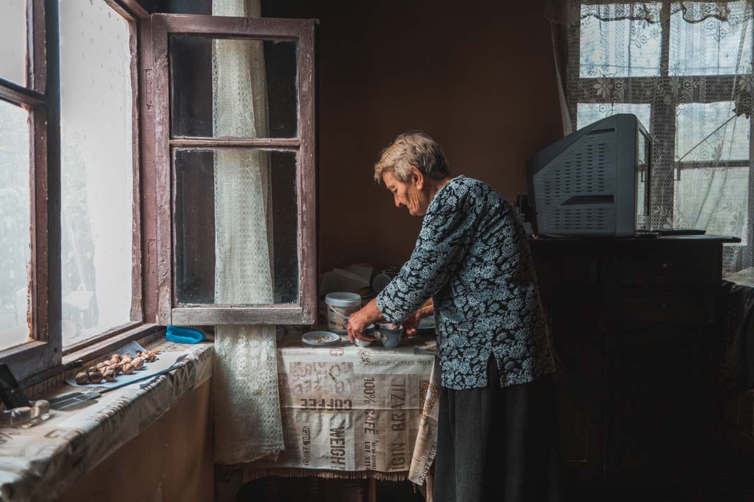 Nora prepares coffee in her kitchen. She lives in Khurvaleti, a Georgian village surrounded by the line of separation.