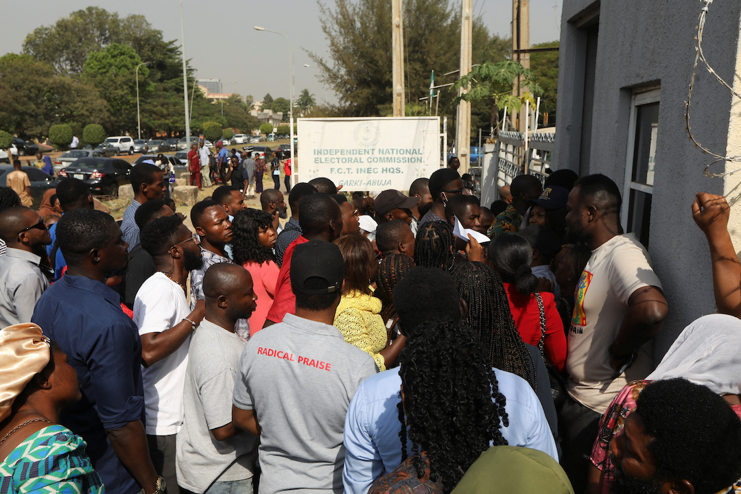 People wait to collect their permanent voters cards at the INC office in area 10, in Abuja, Nigeria December 13, 2022.