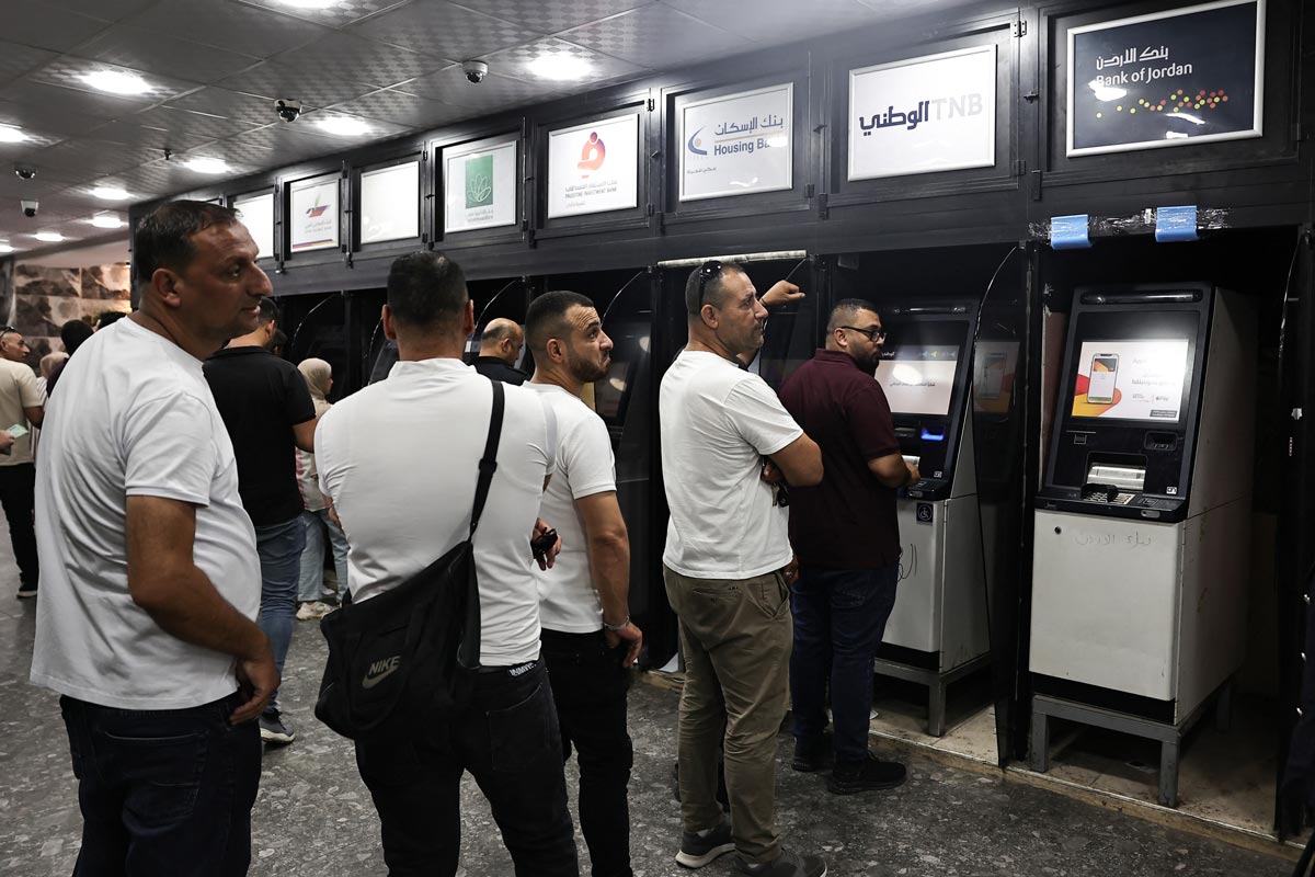 Palestinians withdraw money from ATM's at a bank in the northern Palestinian city of Nablus, in the Israeli occupied West Bank on June 9, 2024.