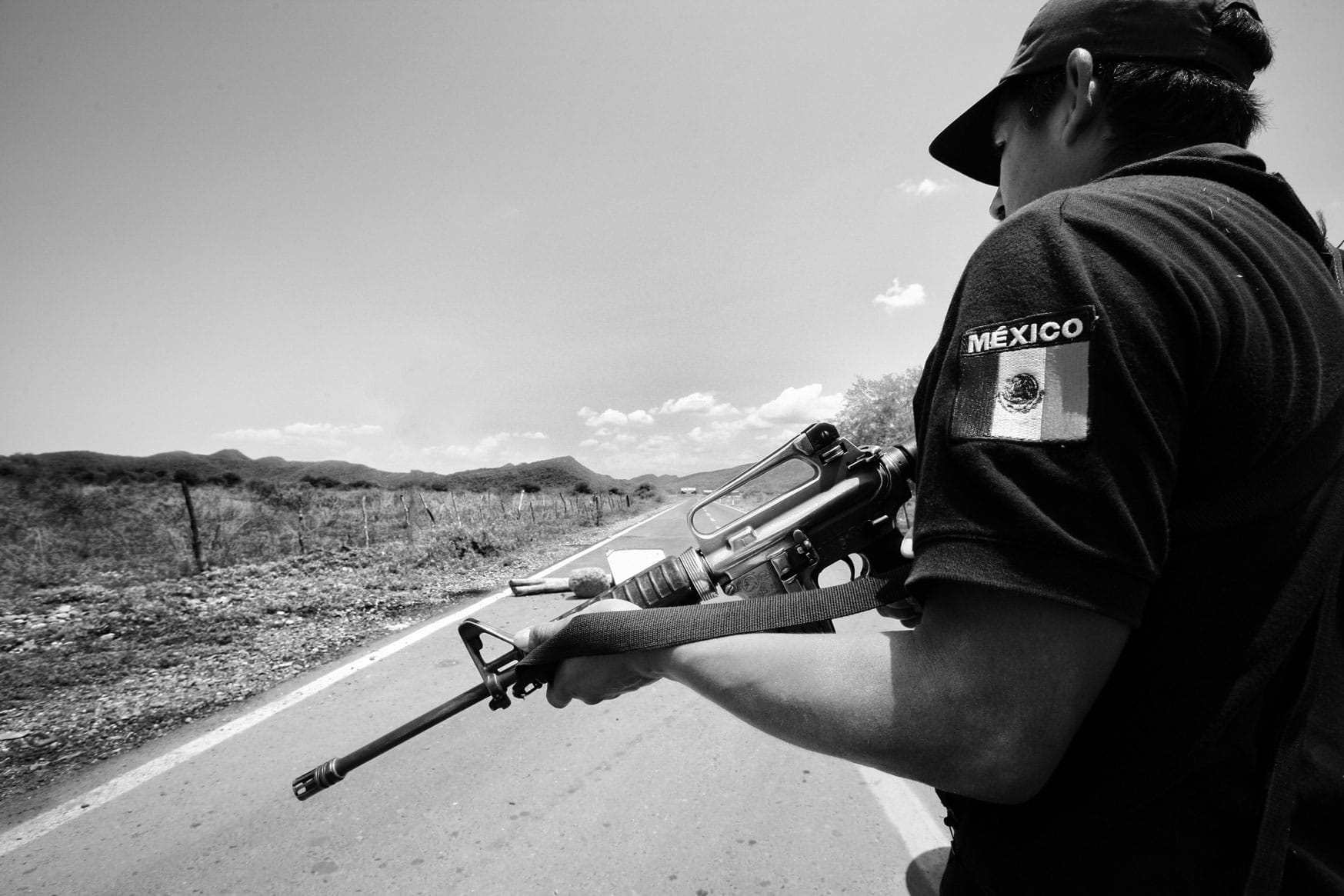 Grupos de autodefensas (self-defender groups) in Mexico stand watch on a highway road.