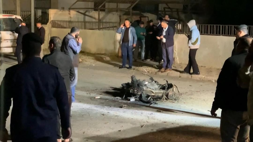 An image grab from AFPTV footage shows Jordanian onlookers and security agents standing around the debris of a missile intercepted over Amman amid an unprecedented Iranian drone and missile attack on Israel in the early hours of April 14, 2024