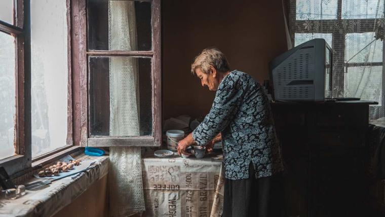 Nora prepares coffee in her kitchen. She lives in Khurvaleti, a Georgian village surrounded by the line of separation.