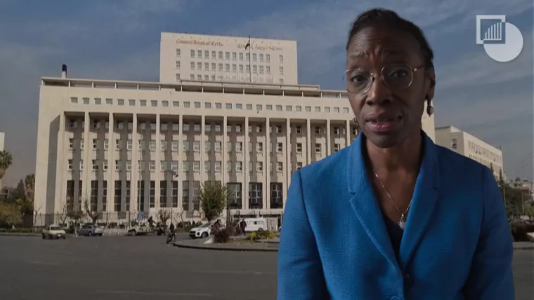 Comfort Ero in front of a building in Syria