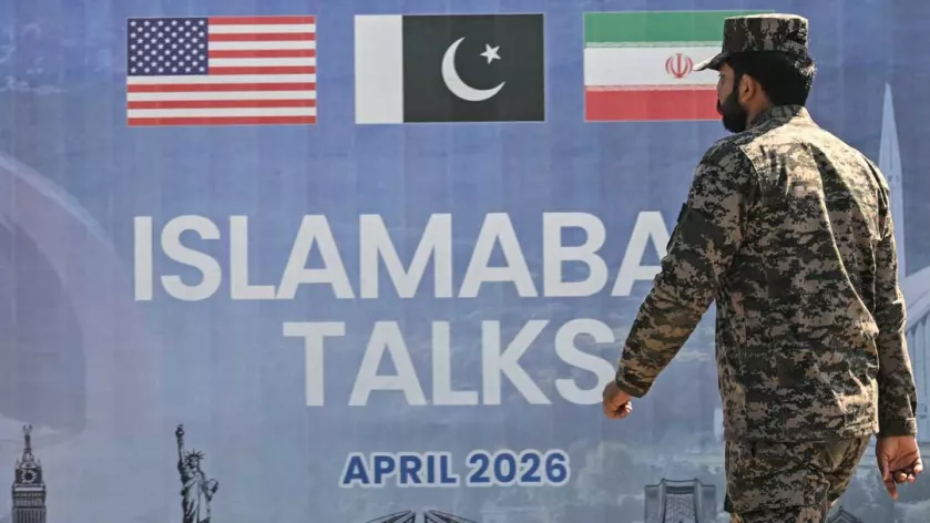 A Pakistani Ranger walks past a billboard for the US-Iran peace talks in Islamabad on April 12, 2026. Iran and the United States failed to reach an agreement to end the war in the Middle East, US Vice President JD Vance said on April 12 after marathon talks in Islamabad, adding that he was leaving negotiations after giving Tehran the "final and best offer".