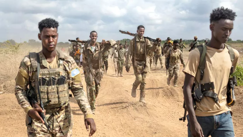 Soldiers of the Somalia National Army (SNA) walk near the frontlines at Sabiid, one of the towns they have liberated from the Al-Qaeda-linked militants, Al-Shabaab, in Somalia's lower-Shabelle region on November 11, 2025. TONY KARUMBA / AFP